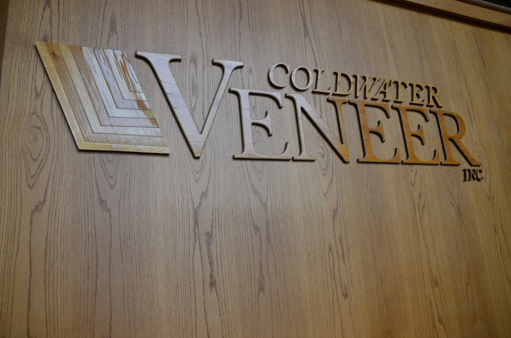 Coldwater Veneer Logo made of wood on wooden wall in corporate office